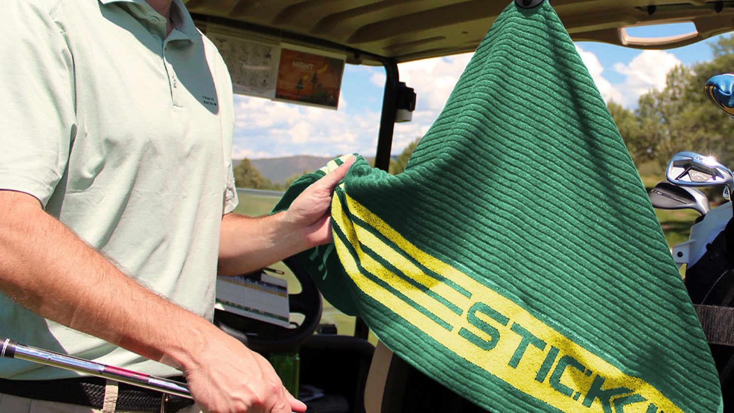 Man holding a green STICKIT XL Magnetic Golf Towel