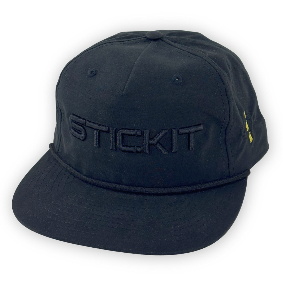 Black snapback hat with embroidered "STICK.IT" logo, crafted from durable cotton for stylish everyday wear.