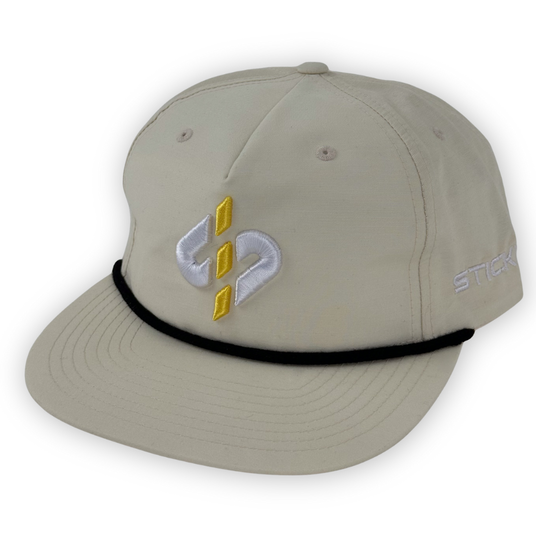 Beige embroidered cap with yellow and white designs, featuring a black adjustable band and stylish snapback closure.
